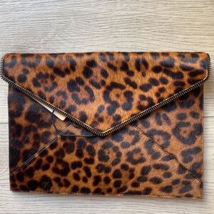 Brown and black cheetah print clutch with a zipper closure and interior pocket